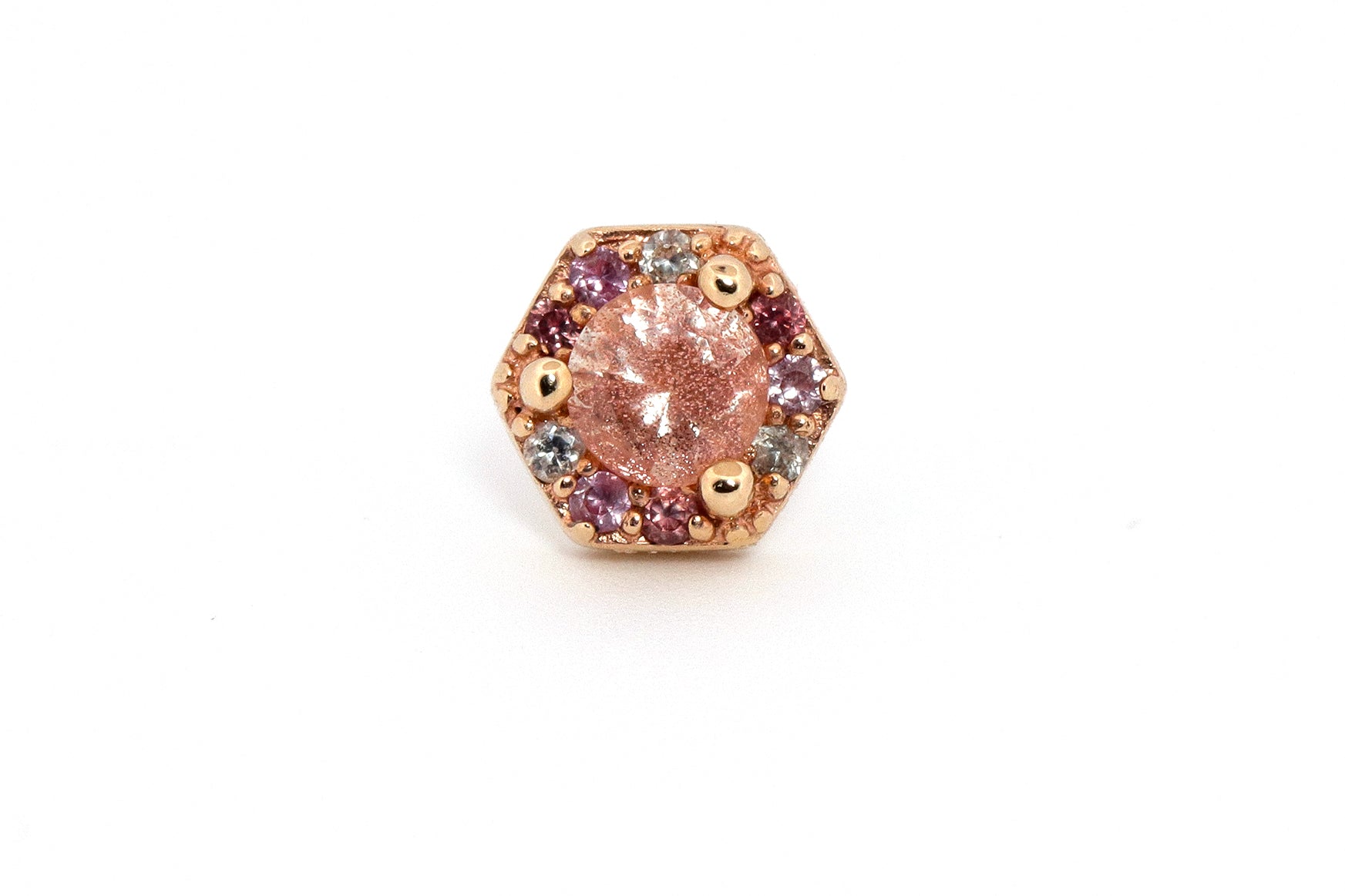 genuine gemstones are set in a solid gold hexagon around a beautiful cut of Oregon Sunstone. Ornamented with an alternating pattern of Pink Sapphire, and Lavender Sapphire
